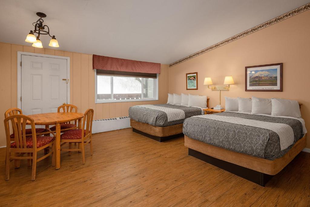 a hotel room with two beds and a desk at Chena Hot Springs Resort in Chena Hot Springs