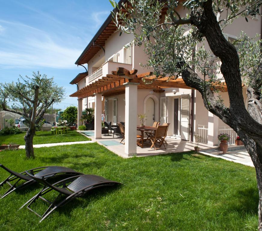 a house with a lawn in front of it at B&B Alle Tre Rose in Montignoso