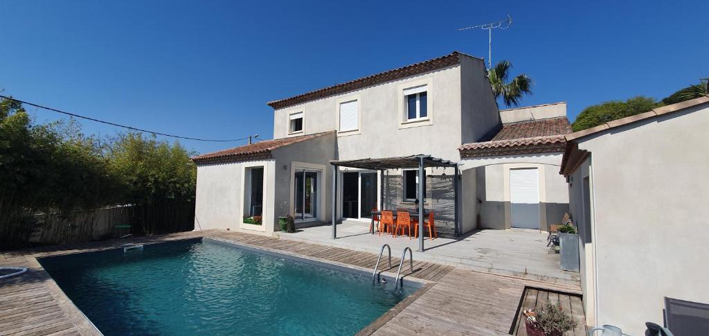 una casa con piscina di fronte a una casa di Chambre à Bouzigues dans villa individuelle a Bouzigues