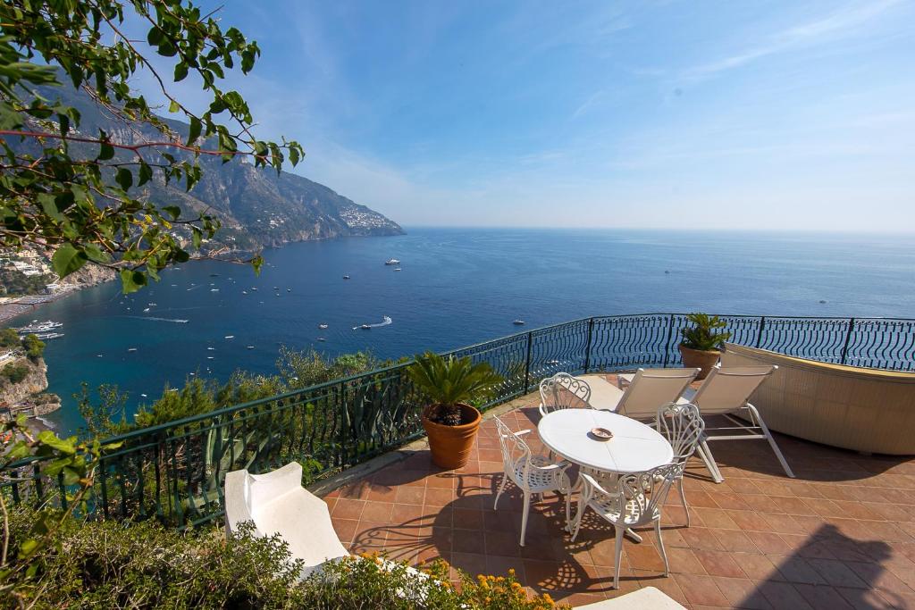 a balcony with a table and chairs and the ocean at Positano Luxury Villas in Positano