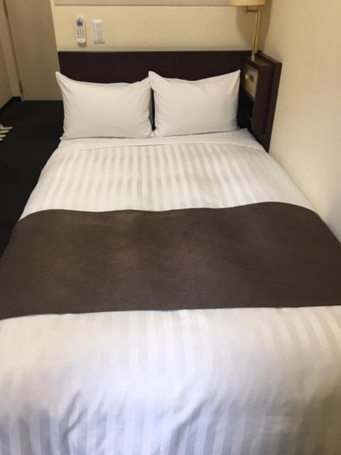 Postel nebo postele na pokoji v ubytování Fuchu Urban Hotel Annex