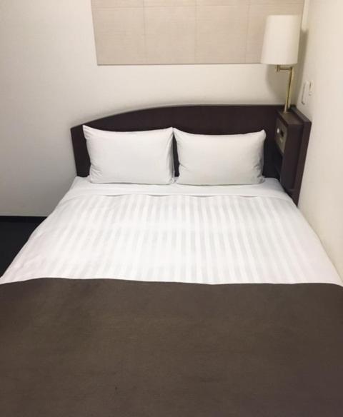 Postel nebo postele na pokoji v ubytování Fuchu Urban Hotel Annex