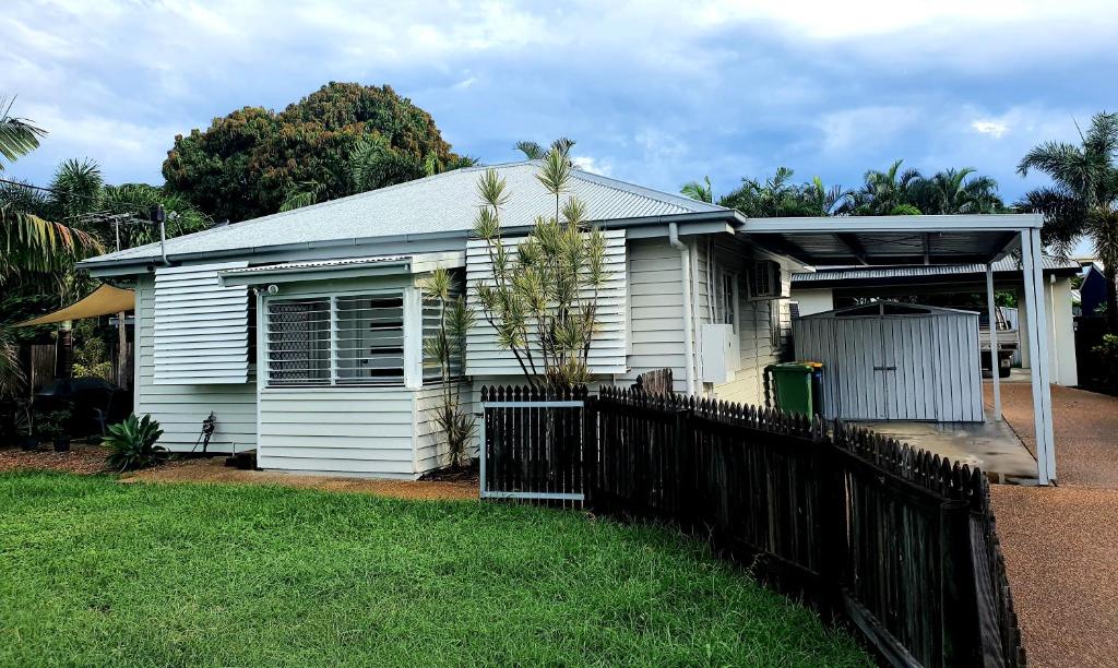 a white house with a fence in front of it at 2 bedroom cottage in Townsville
