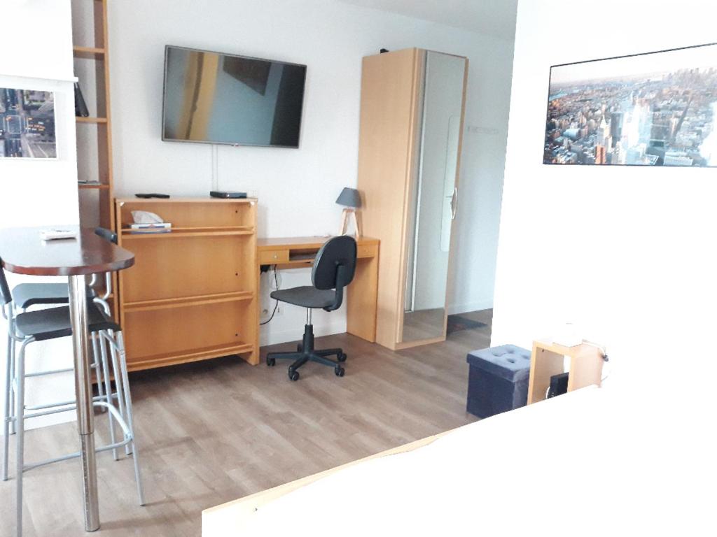 um escritório com uma secretária, uma cadeira e uma televisão em Studio Santa Monica - Climatisé - Piscine - Parking em Toulouse