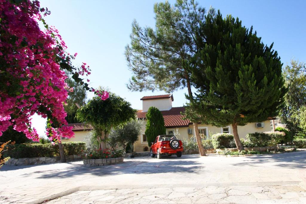 a red car parked in front of a house at Alonia Villas in Pissouri