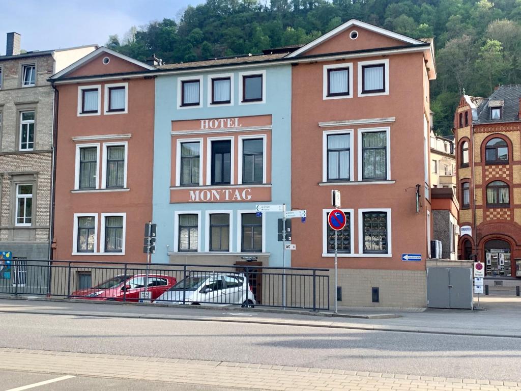 un edificio con dos coches estacionados frente a él en Hotel Montag en Sankt Goar