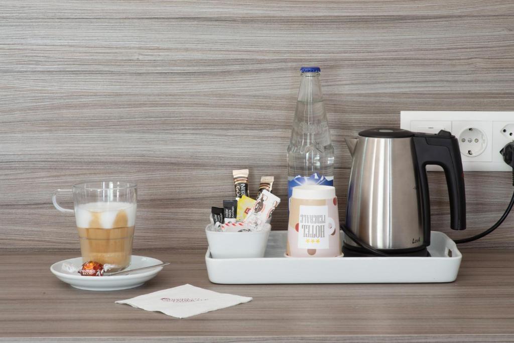 a tray with a coffee maker and a drink at Hotel Federale in Lugano