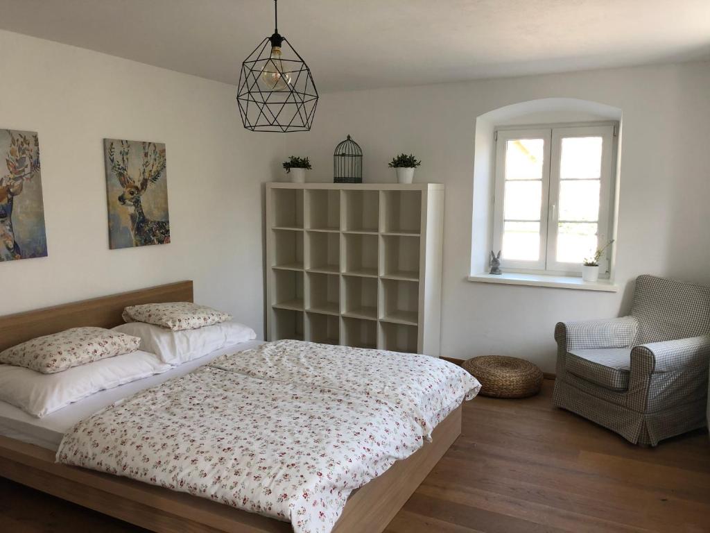 una camera con due letti e una sedia e una finestra di Fancy Luxury Home In Former Tavern a Gmunden