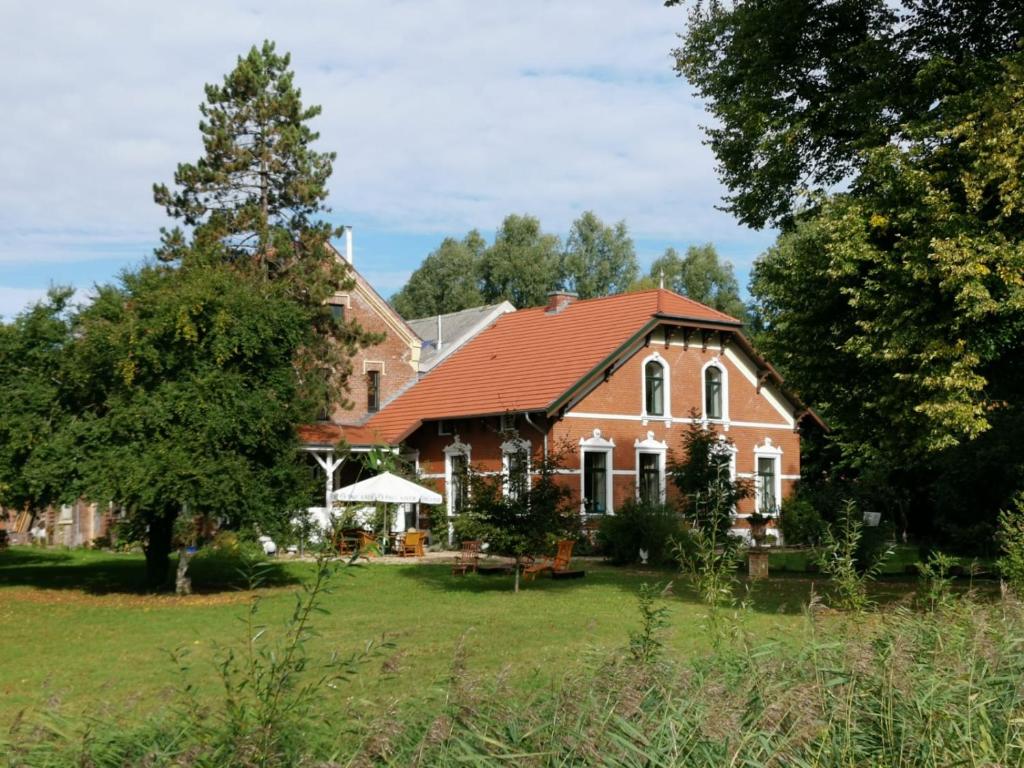 une grande maison en briques avec un toit rouge dans l'établissement Johannes Hof, à Bunde