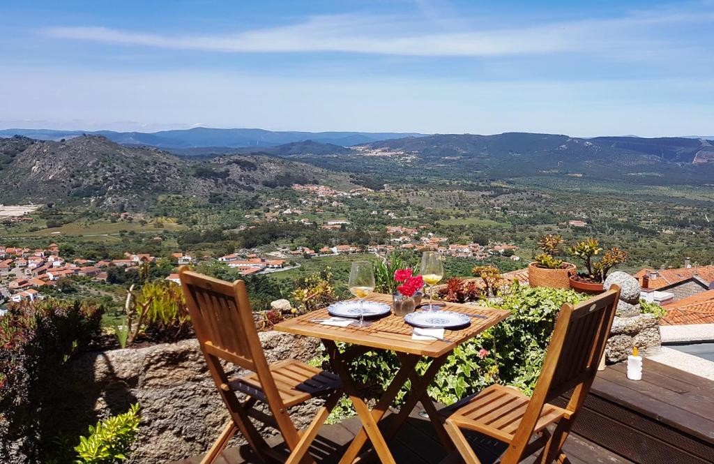 a table and chairs on a balcony with a view at CASA DO CASTELLO MONSANTO in Monsanto