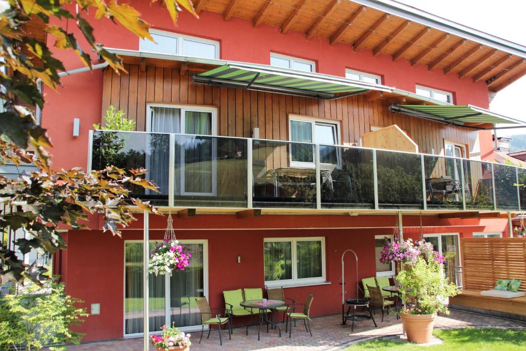 Casa con balcón con mesas y sillas en Apartment Dahoam, en Forstau