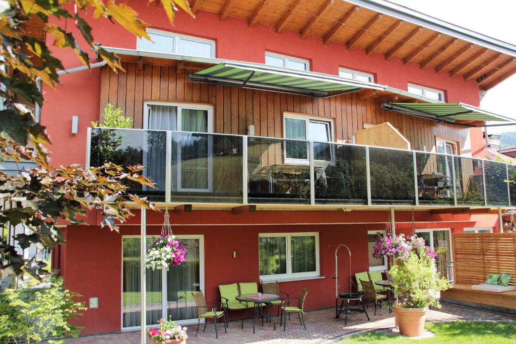 a house with a balcony with tables and chairs at Apartment Dahoam in Forstau