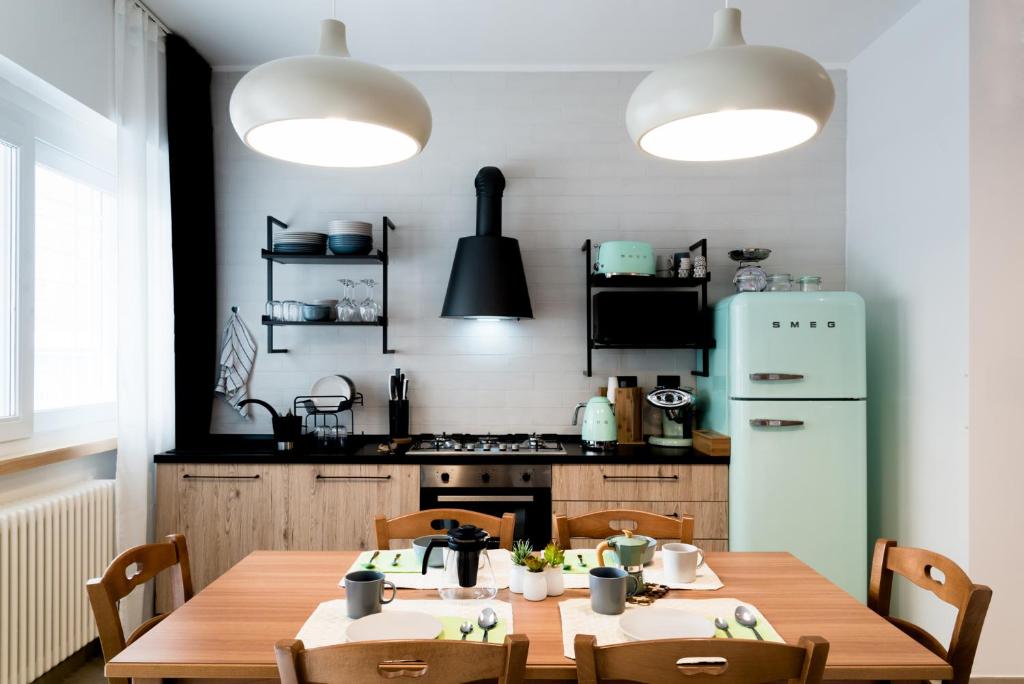una cucina con un tavolo di legno con sedie e un frigorifero di BOTTASSO17 Guest House a due passi dal mare a Terracina