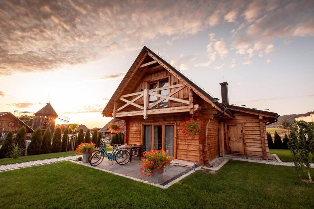 uma cabana de madeira com uma bicicleta estacionada fora dela em Bajkowe Domki em Kudowa-Zdrój
