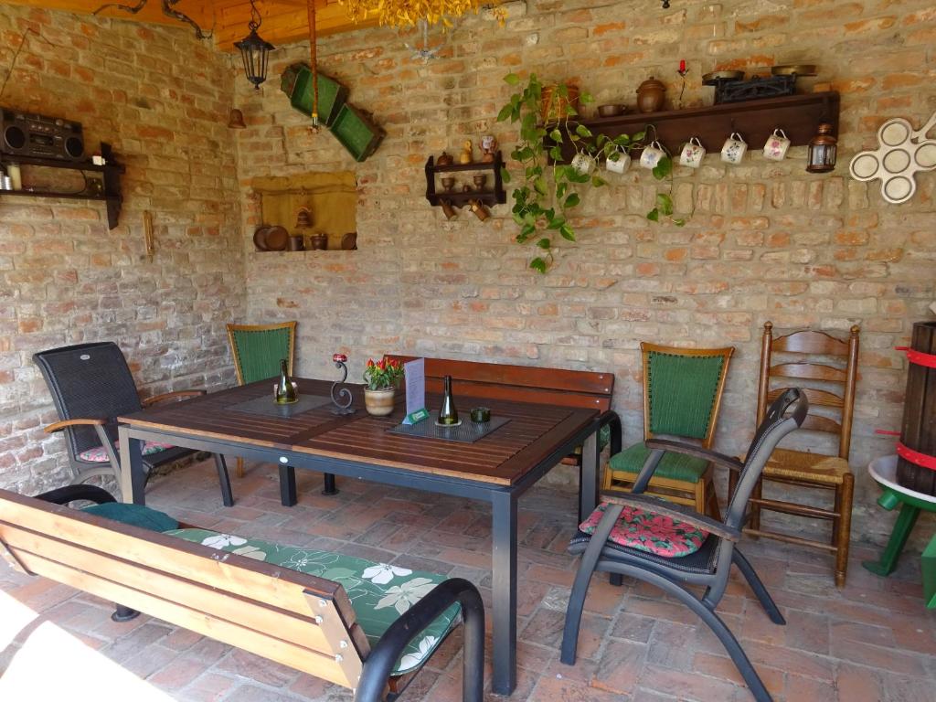 Ubytovani Dana Brentnerova في Milovice: فناء مع طاولة وكراسي خشبية