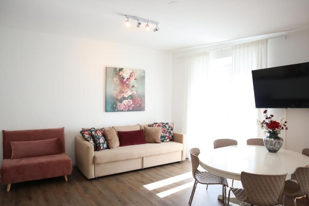 uma sala de estar com um sofá e uma mesa em Bungalow Apartment FREE Parking & Self Check-in em Graz
