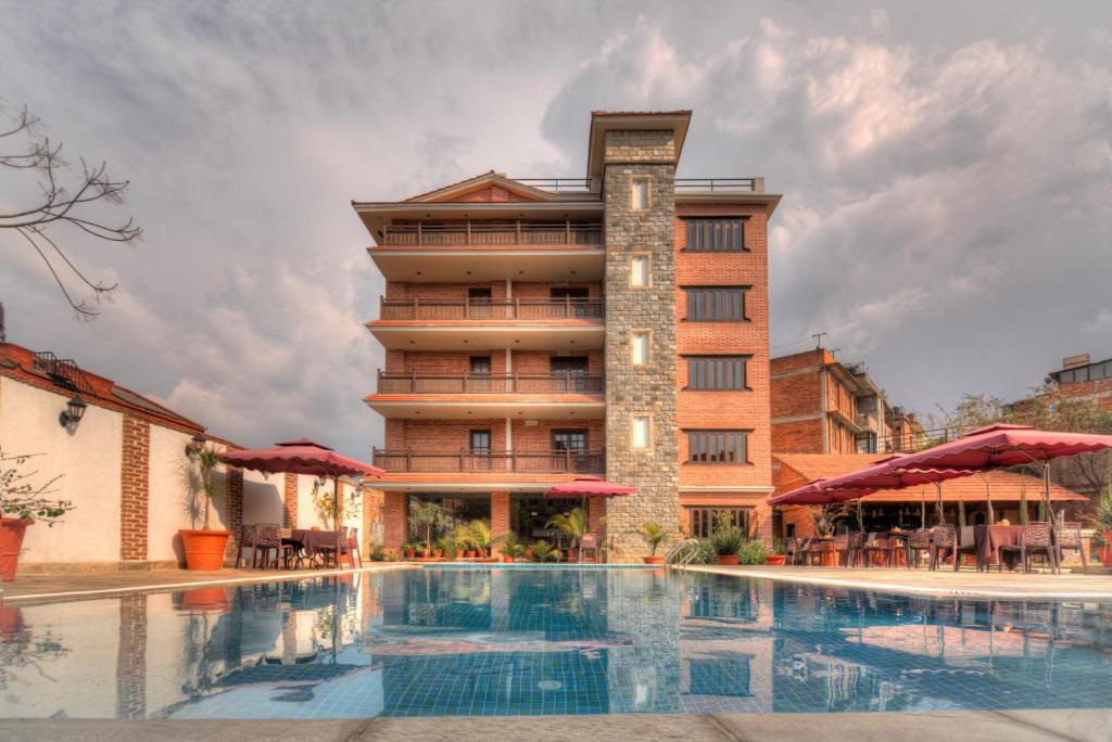 un hotel con piscina di fronte a un edificio di Hotel Bhadgaon a Bhaktapur