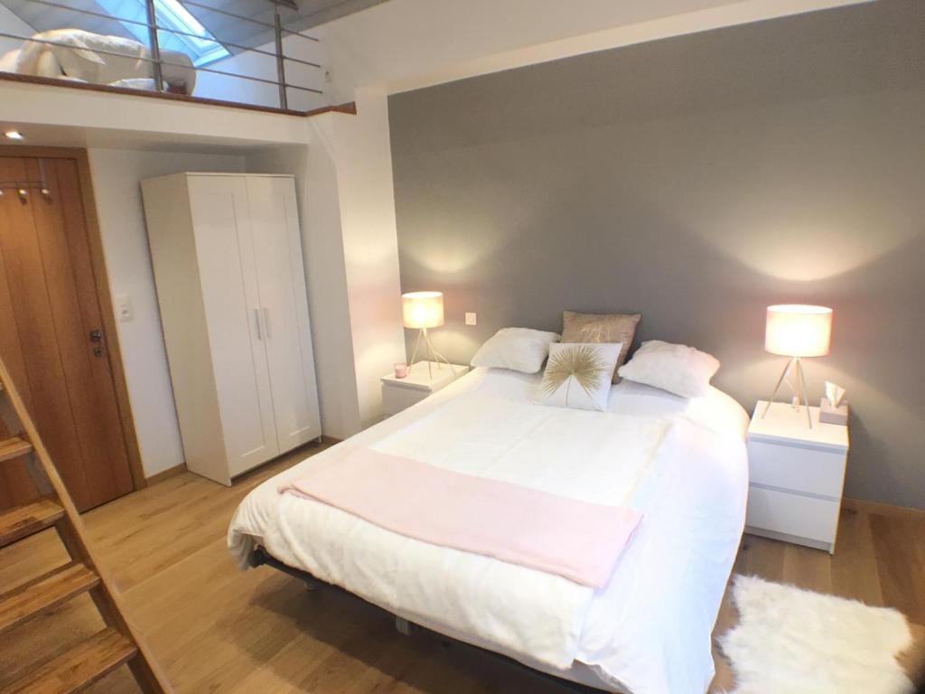 een slaapkamer met een groot wit bed met 2 lampen bij B&B Pegasus II - Chambre de luxe avec sauna privatif in Vielsalm