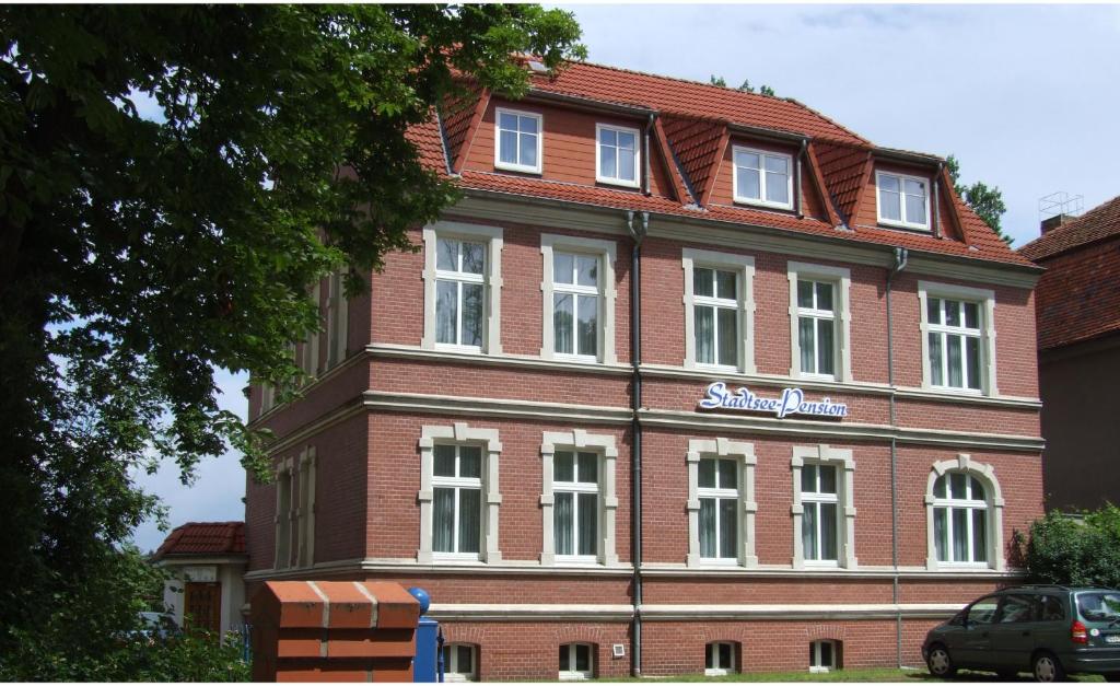 un edificio de ladrillo rojo con un cartel. en Stadtsee-Pension Templin en Templin