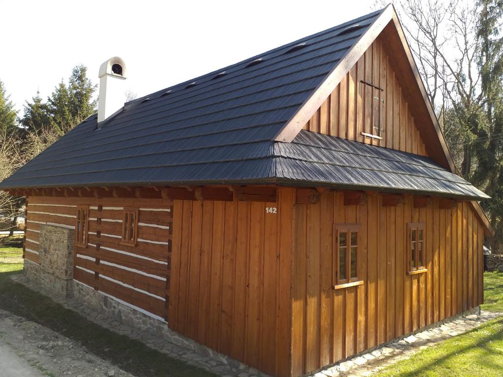 un grand bâtiment en bois avec un toit en métal dans l'établissement Roubenka Telecí, à Telecí