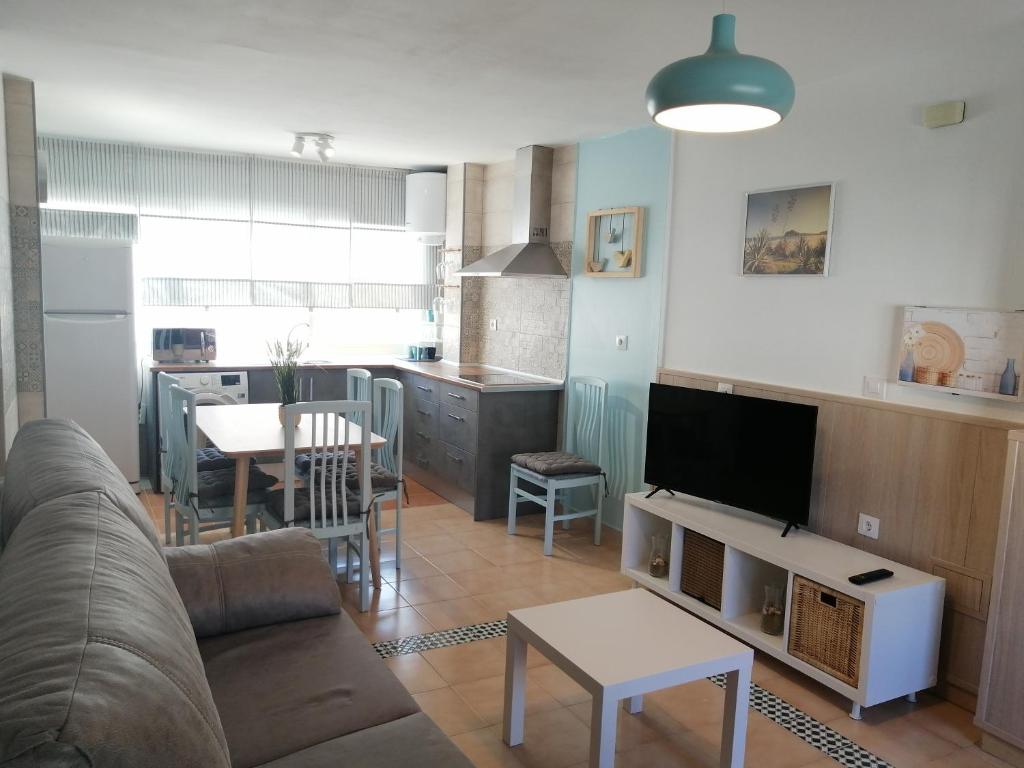 ein Wohnzimmer mit einem Sofa und einem Tisch sowie eine Küche in der Unterkunft Casa Isabel in San José