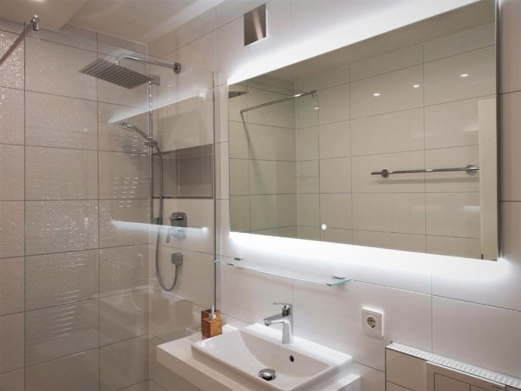 a bathroom with a sink and a mirror at INSIDER Appartement in Schonwald im Schwarzwald