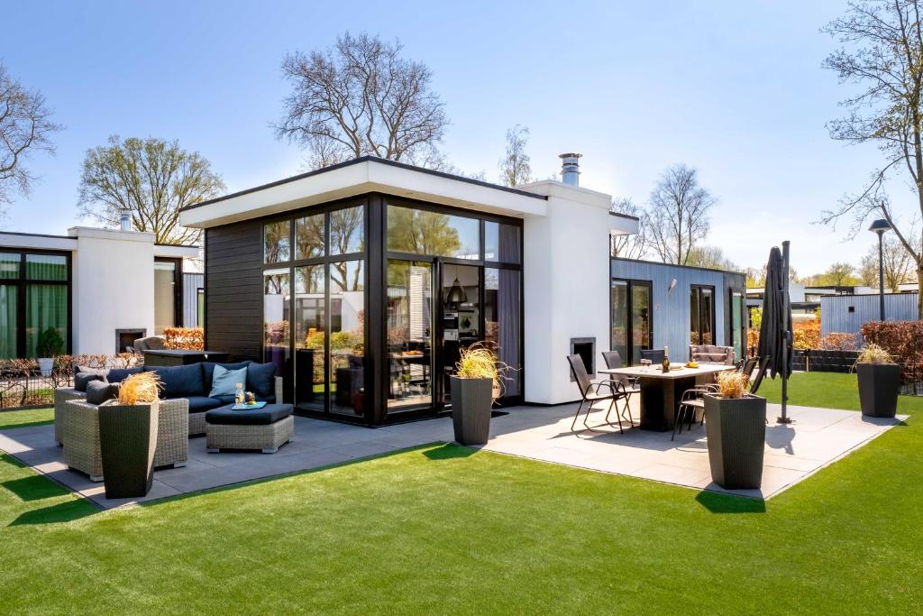a house with a garden with a patio at Cube of Luxury direkt am Strand EuroParcs Bad Hoophuizen in Hulshorst