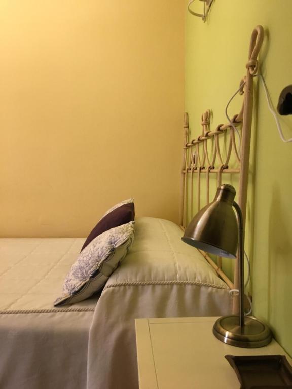 1 dormitorio con 1 cama con lámpara en el escritorio en Casa Rural La Antigua Tahona, en Candelario