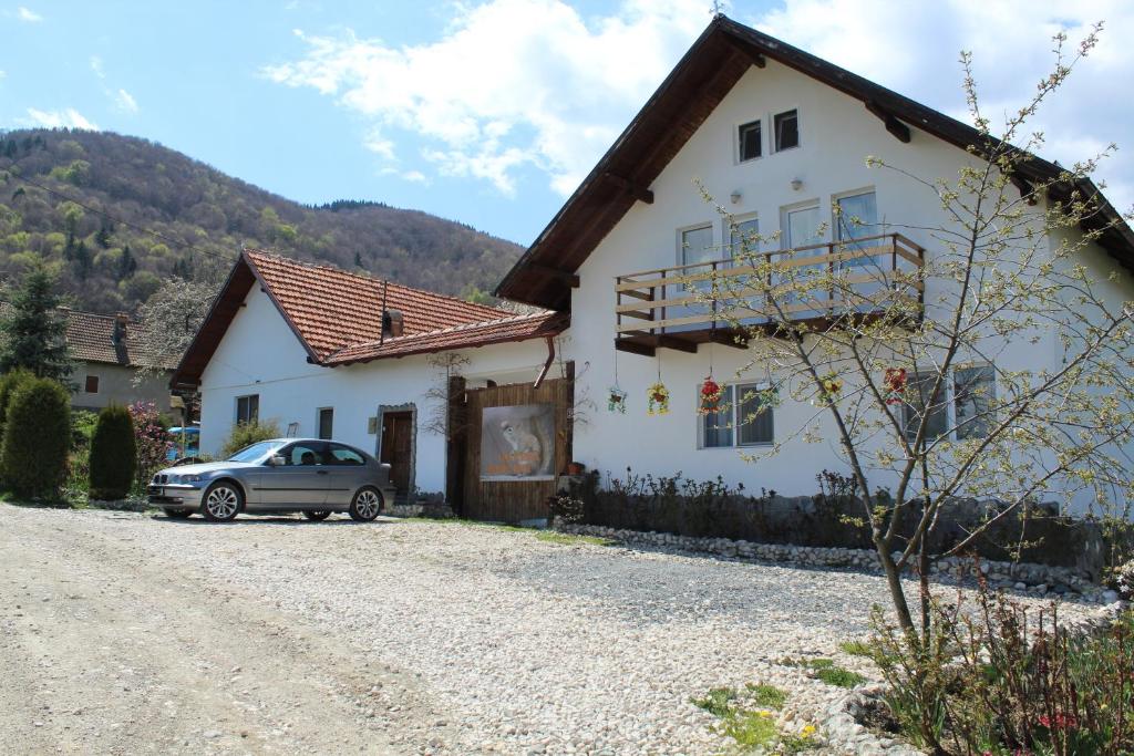 uma casa branca com um carro estacionado na garagem em Casa Veverita em Predelut