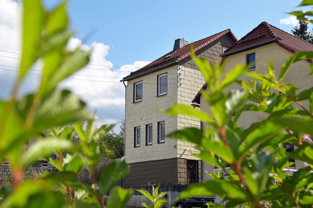 uma casa é mostrada através das folhas das árvores em Monteurhaus-Arbeiterunterkunft Haus Markus Suhl em Suhl