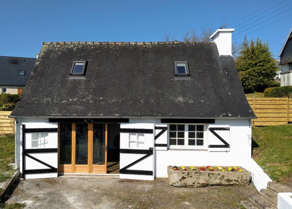 ein kleines weißes Haus mit schwarzem Dach in der Unterkunft Ti Baou in Châteauneuf-du-Faou