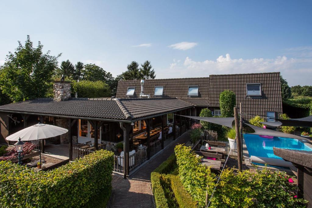een extern uitzicht op een huis met een zwembad bij Hotel Buxus in Gasselte