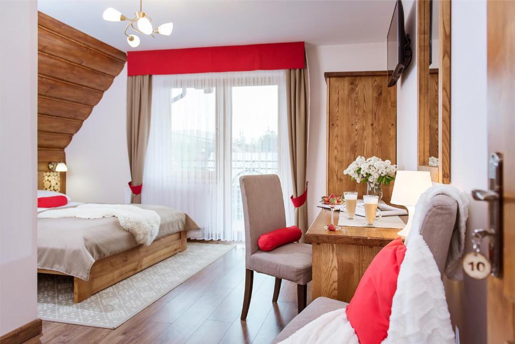 1 dormitorio con 2 camas, escritorio y mesa en Dom Wypoczynkowy Koliba en Białka Tatrzanska