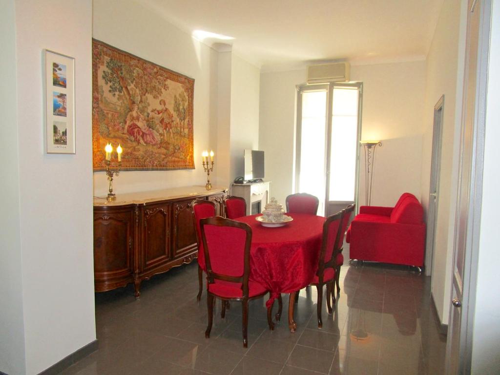 uma sala de jantar com uma mesa vermelha e cadeiras em Appartement em Nice