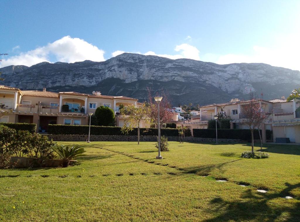 a park with houses and a mountain in the background at El Respiro verde in Denia