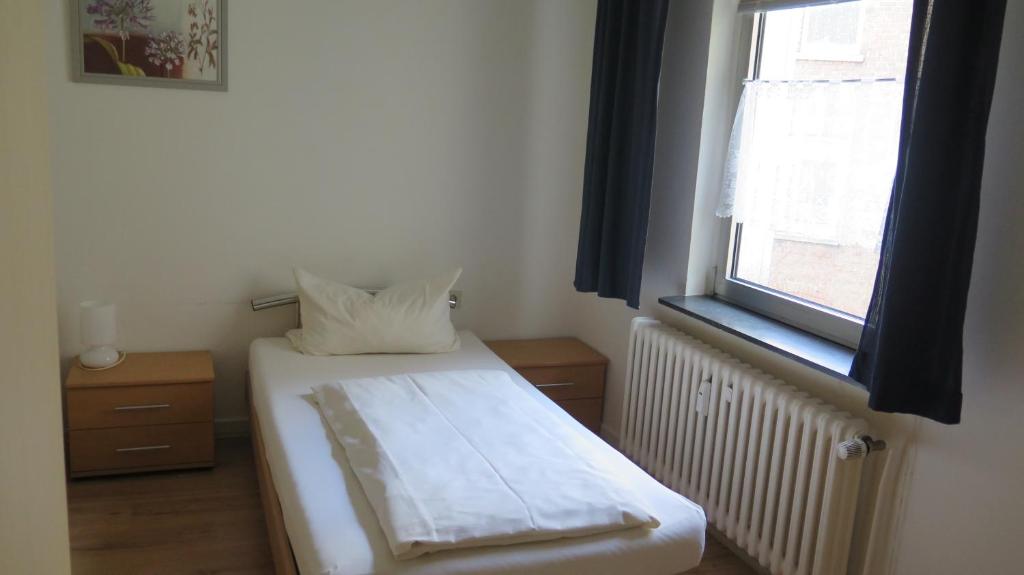 ein kleines Schlafzimmer mit einem Bett und einem Fenster in der Unterkunft Johnny's wohnen auf Zeit in Duisburg