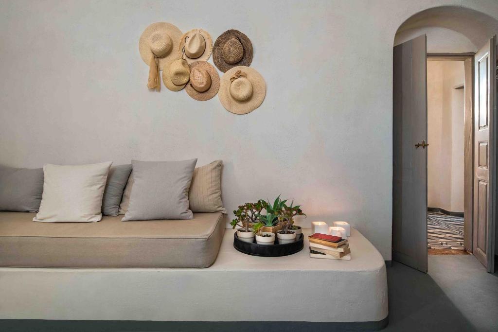 a living room with a couch with hats on the wall at Sandandstone villa Santorini in Megalochori