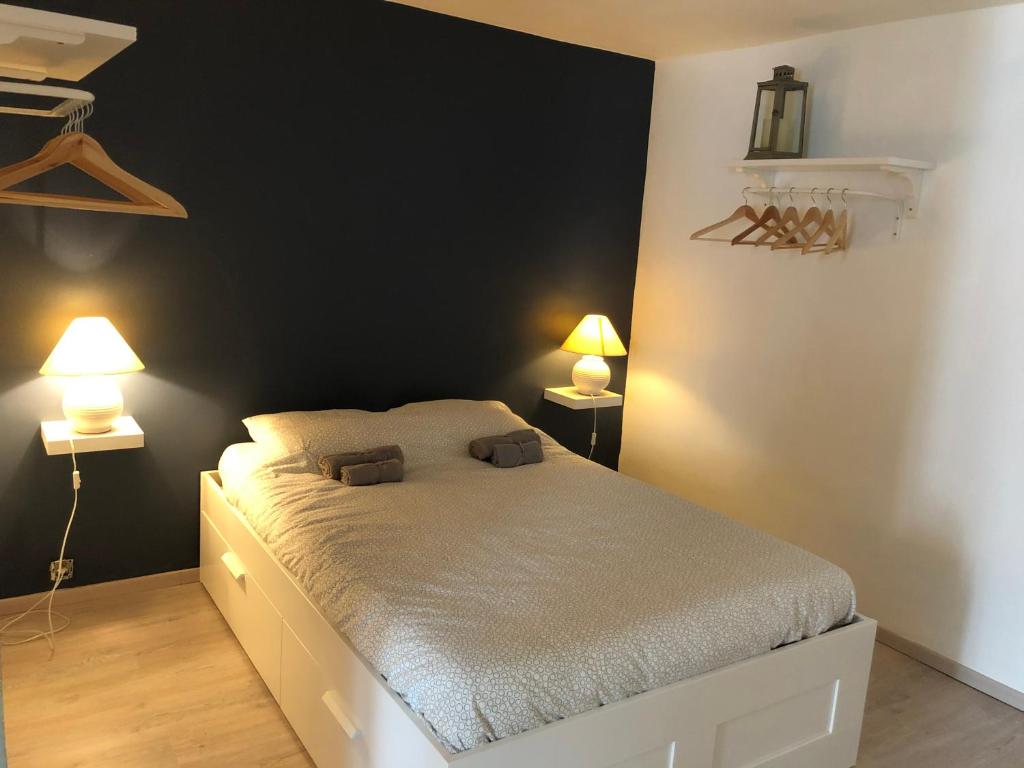 een slaapkamer met een bed met twee lampen erop bij L’Appart’ de Spa in Spa