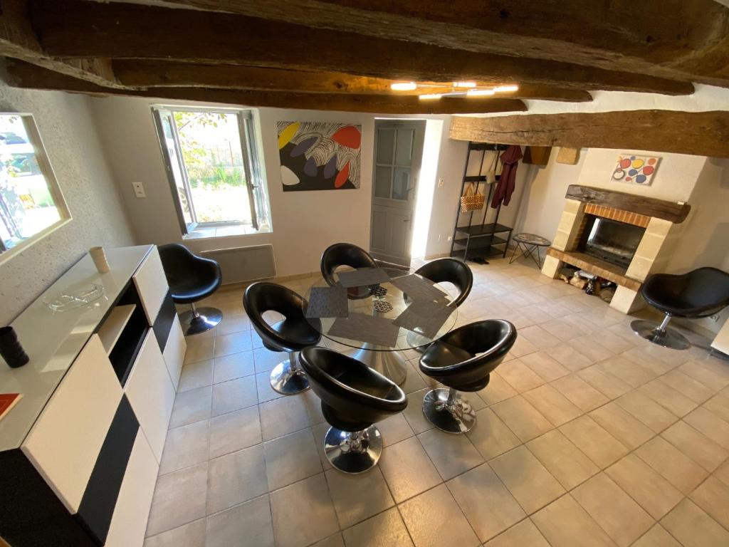 a dining room with a glass table and black chairs at Le 38, gite 2 chambres proche commerces in Saché