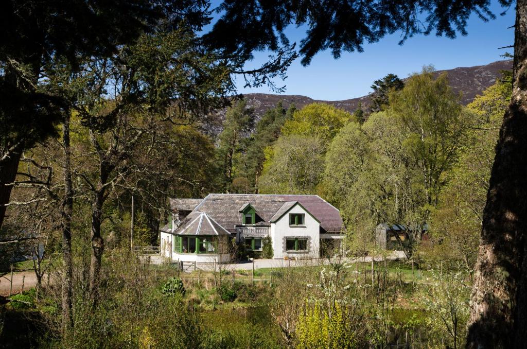 a white house in the middle of a forest at Glentruim Homestay B&B in Newtonmore