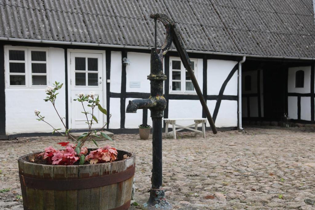 a wooden barrel with flowers in front of a building at Tøndegården 3 rooms apartment in Odense