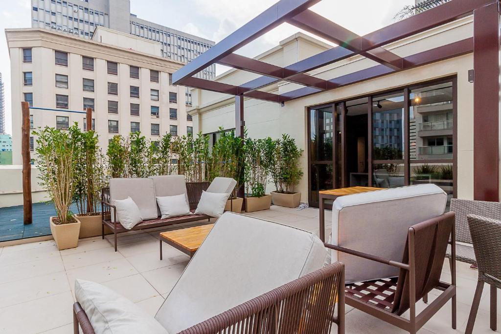 een patio met stoelen en tafels in een gebouw bij Audaar Jacques Pillon Residencial - Centro de São Paulo in Sao Paulo