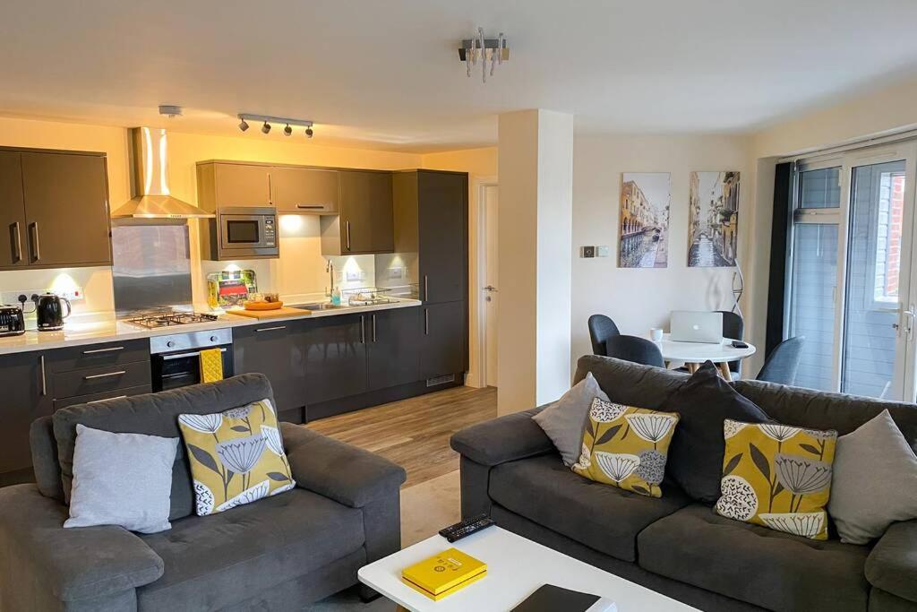 a living room with two couches and a kitchen at 13 The Grosvenor, luxury flat, central Newmarket, in Newmarket