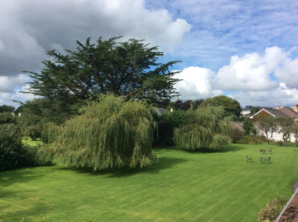 a green field with a tree and picnic tables at The Gardens guest accommodation in Killarney