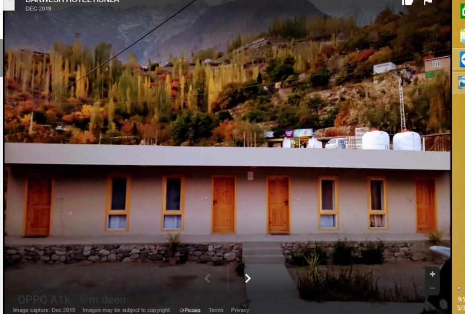 a building with orange doors and a mountain at Darwesh Hotel Hunza in Baltit