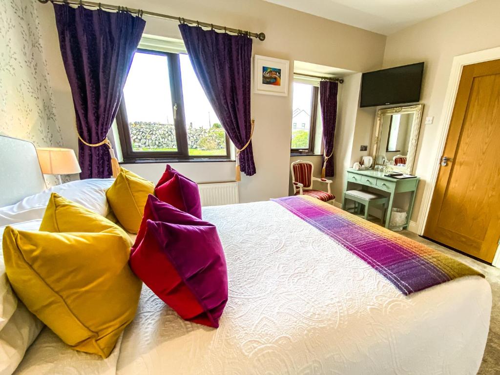 Un dormitorio con una cama con almohadas de colores. en Daly's House en Doolin