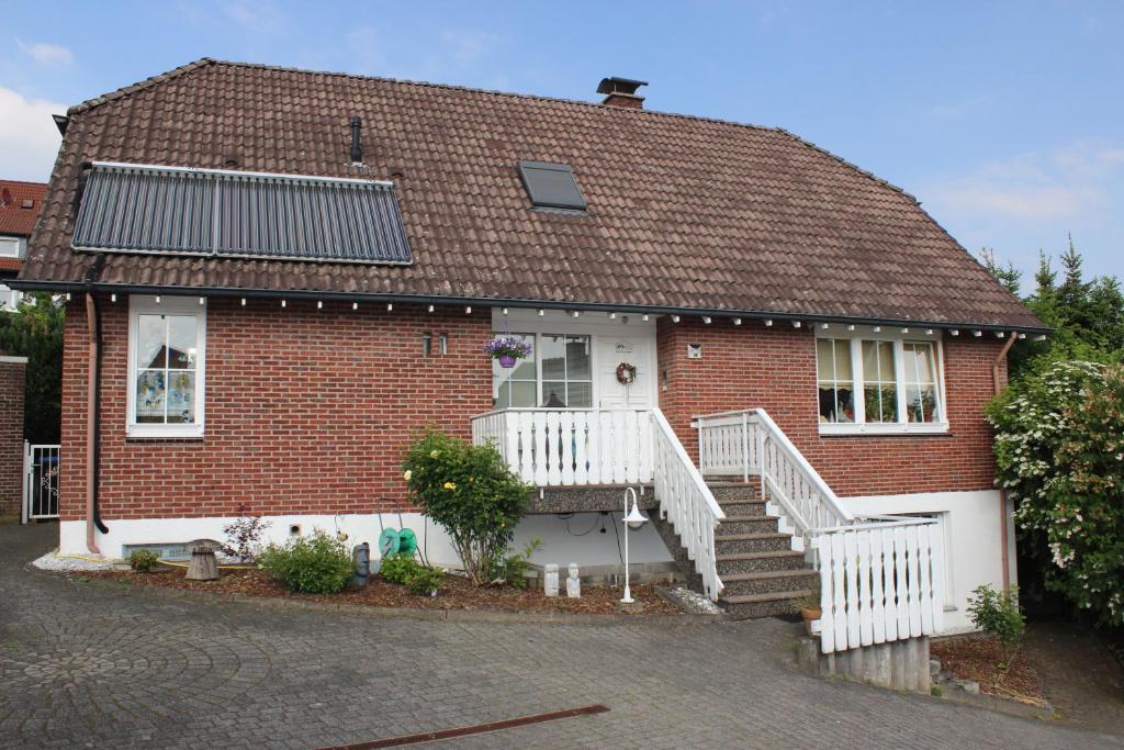 a red brick house with a white porch and stairs at Chrissi und Micha in Remscheid