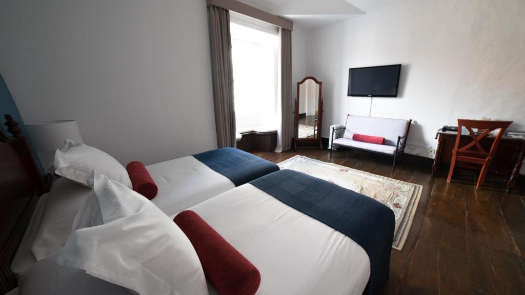 Łóżko lub łóżka w pokoju w obiekcie Hotel Aguere