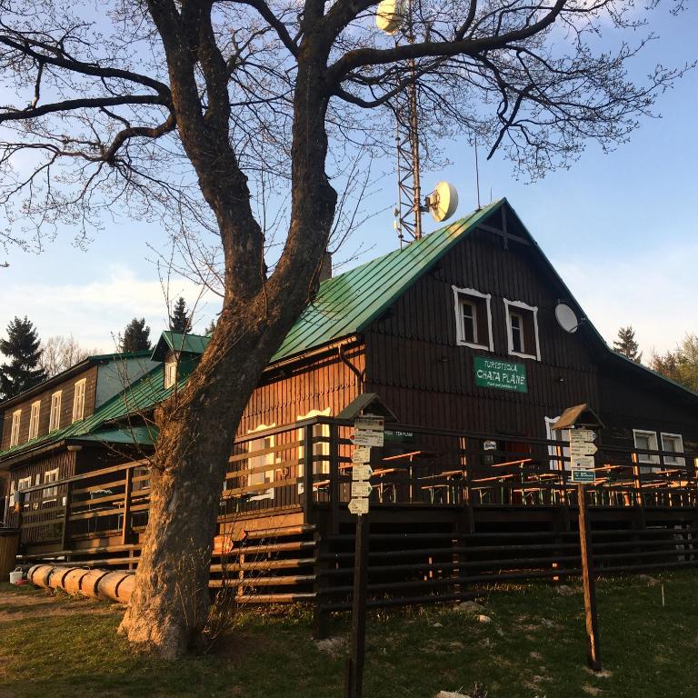 a large wooden building with a green roof at Turistická Chata Pláně in Český Dub