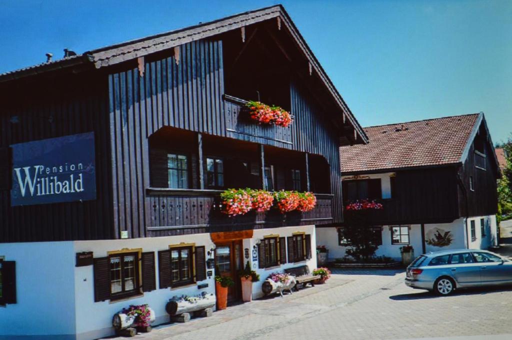 ein Gebäude mit einem davor geparkt in der Unterkunft Pension Willibald in Bad Tölz